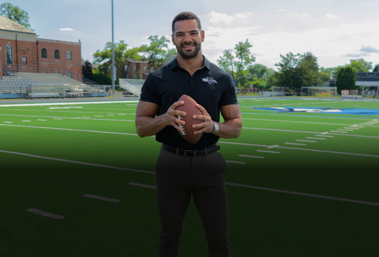 Clay Harbor holding football on football field